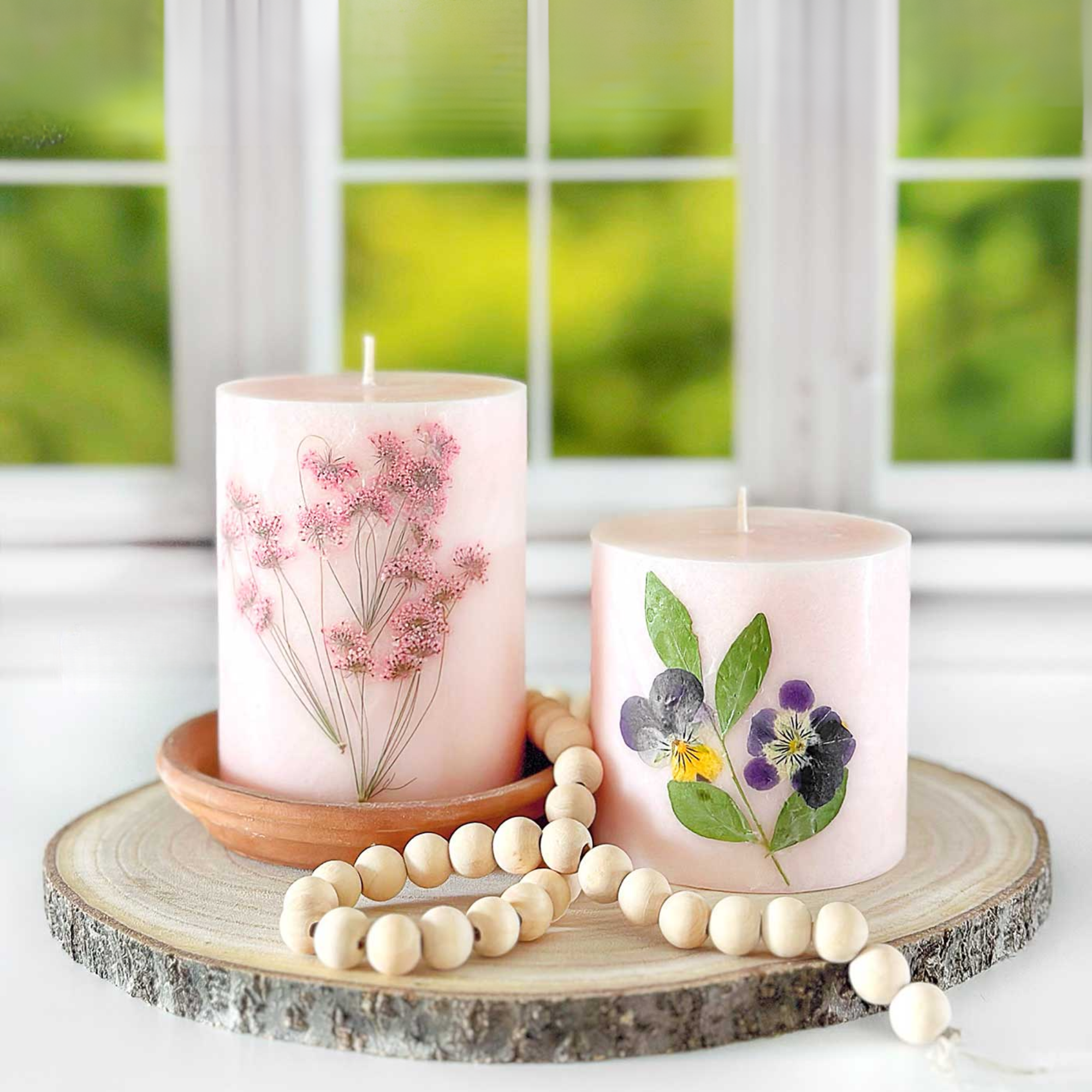 Photo of candles with pressed flowers.