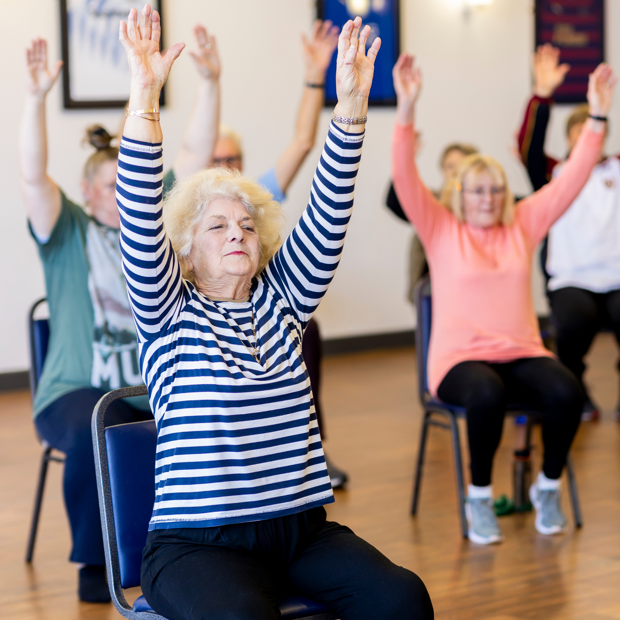 Photo of senior citizens completing chair exercies.