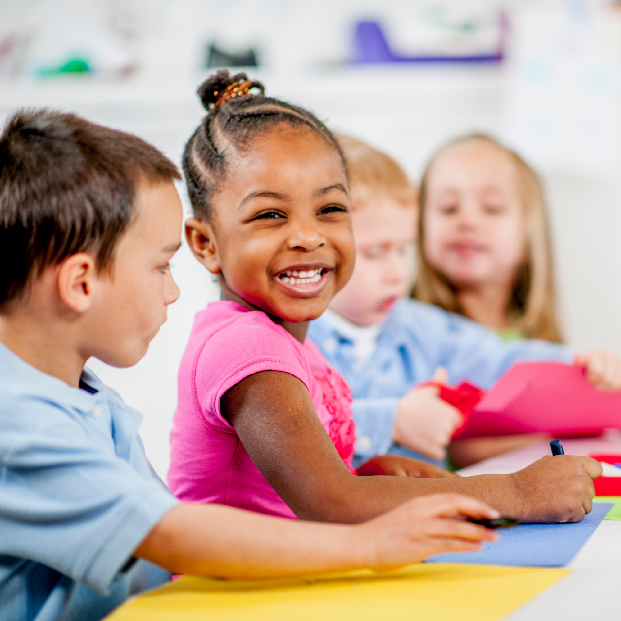 Photo of multiple children smiling and coloring.