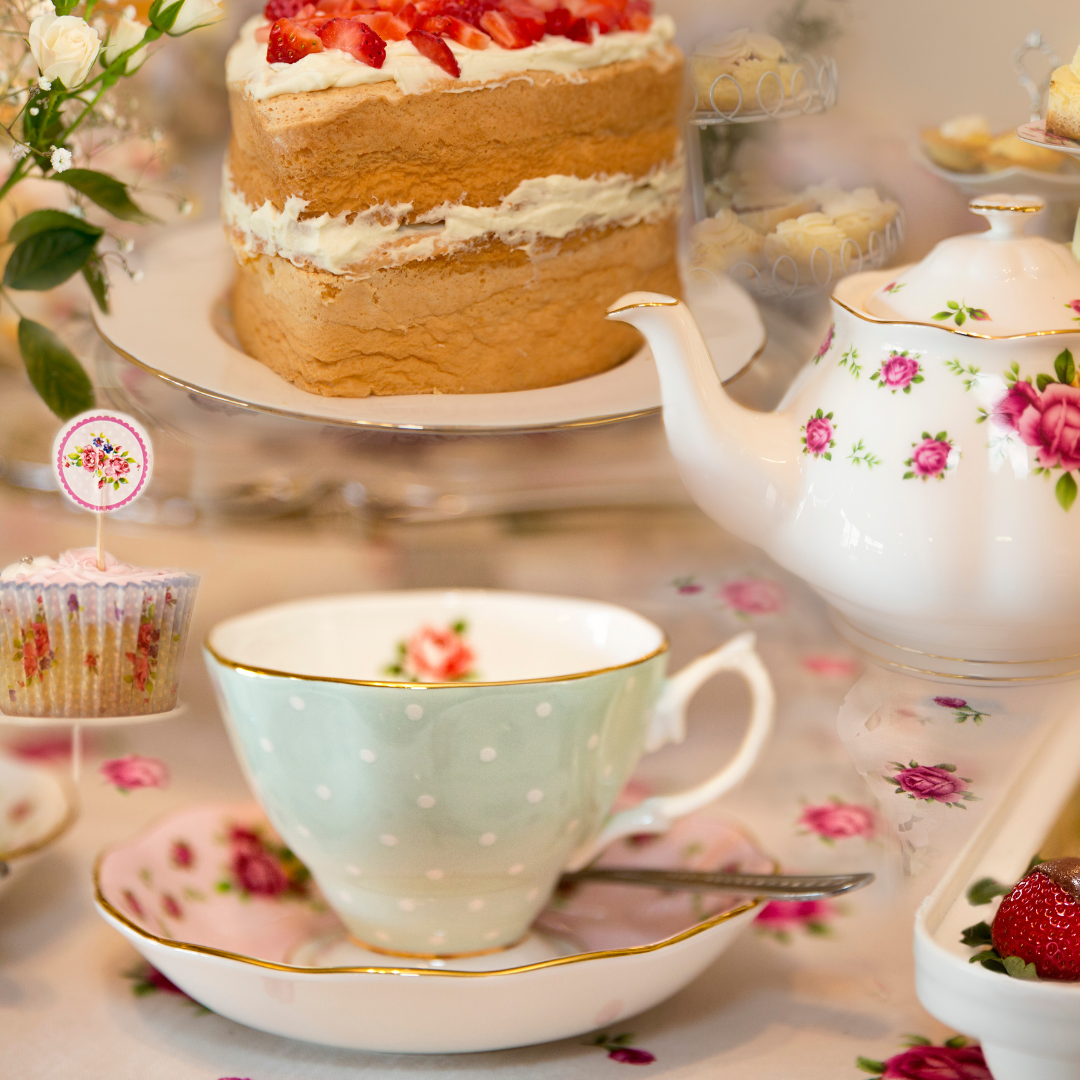 Tea cup with tea kettle and cake