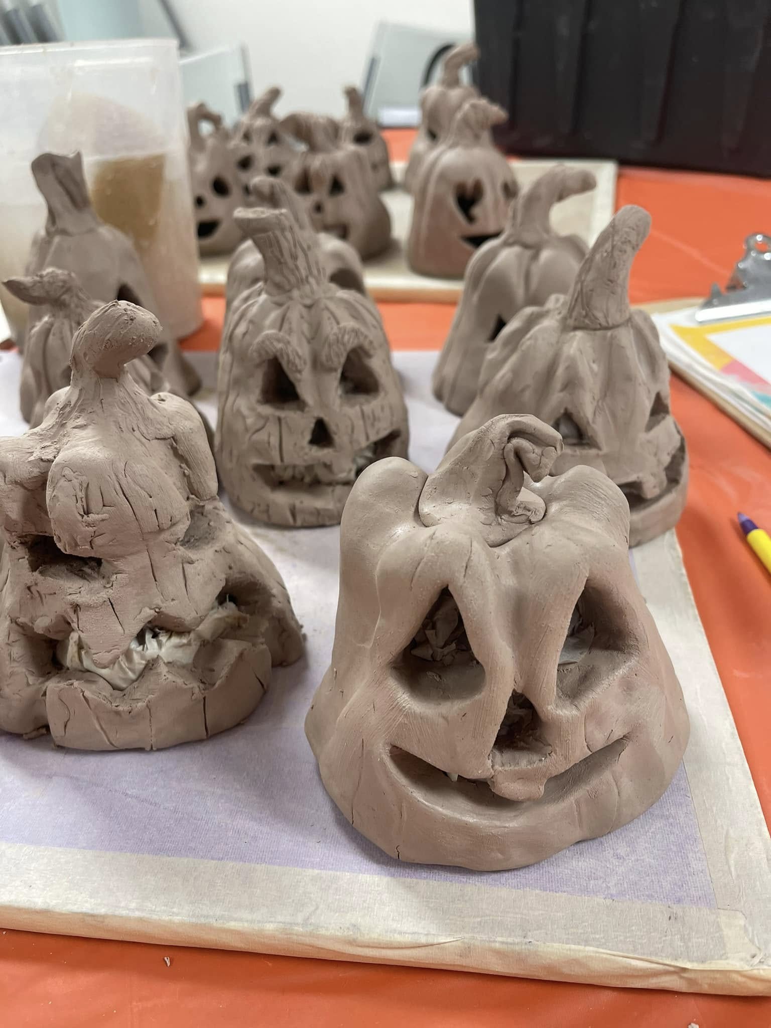 Photo of raw ceramic jack-o-lantern pumpkins.